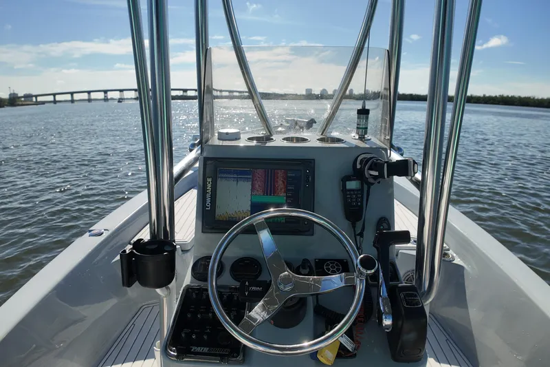 Slide: The Image of 2014 Pathfinder 2200 TRS boat dashboard with steering wheel and navigation equipment on open water. - 8