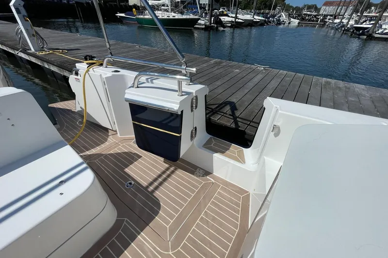 Slide: The Image of 2023 MJM 35 boat with open engine compartment and storage, docked by the water. - 16