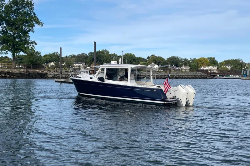 Slide: The Image of 2023 MJM 35 boat cruising on a calm lake with American flag. - 2