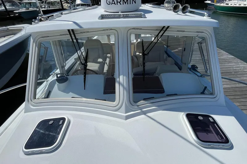 Slide: The Image of 2023 MJM 35 boat docked with dual outboard engines in a marina. - 23