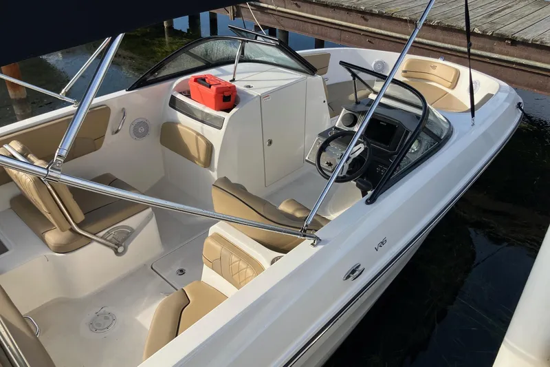 Slide: The Image of 2024 Bayliner VR6 Bowrider OB with tan seating and modern dashboard, docked by wooden pier. - 4