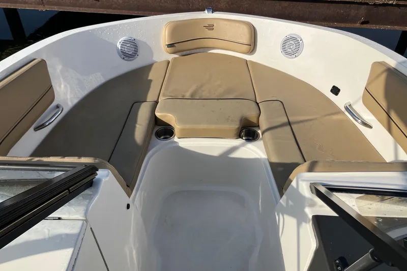 Slide: The Image of 2024 Bayliner VR6 Bowrider OB interior with beige seating and cup holders. - 7