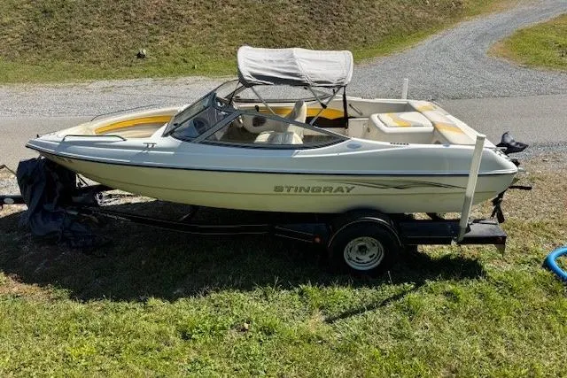 The Image of 2003 Stingray 180LS boat on trailer, parked on grassy area. - 0