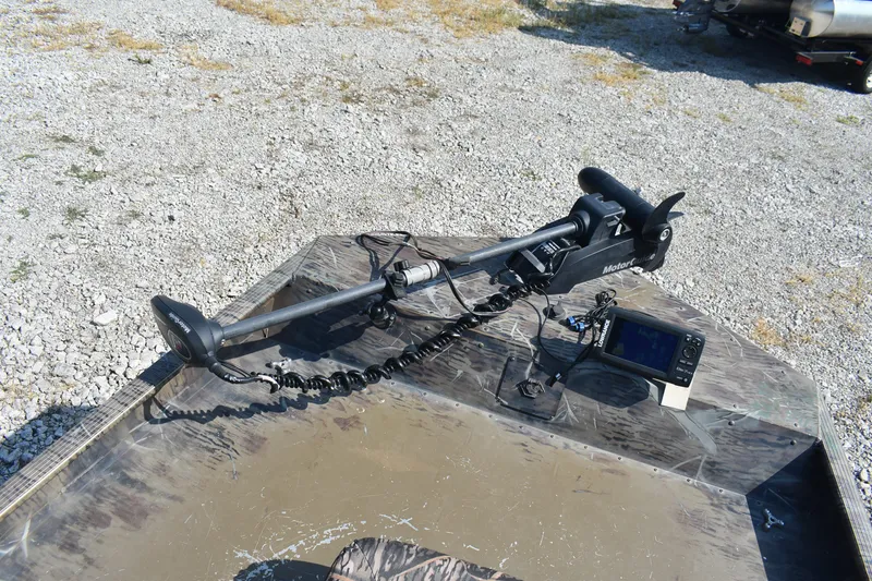 Slide: The Image of 2012 G3 1860 SC CAMO boat with trolling motor and fish finder on gravel. - 12