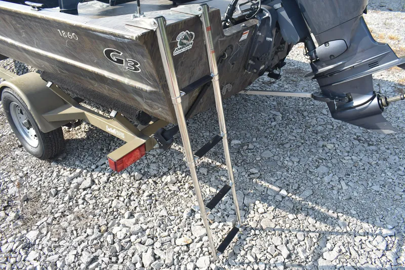 Slide: The Image of 2012 G3 1860 SC CAMO boat with ladder on gravel surface. - 6
