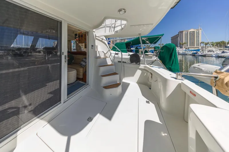 Slide: The Image of 2001 Mainship 390 Trawler yacht deck with stairs, marina view, and interior glimpse. - 12