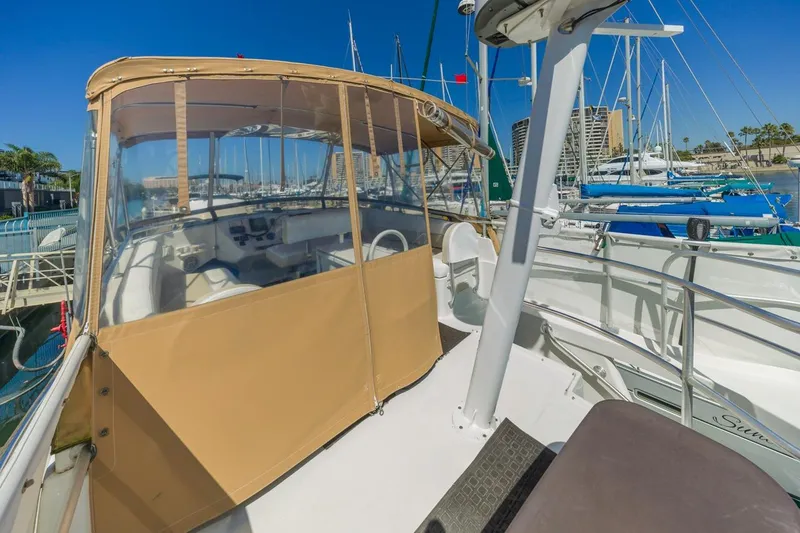 Slide: The Image of 2001 Mainship 390 Trawler docked at marina, featuring spacious deck and helm enclosure. - 14