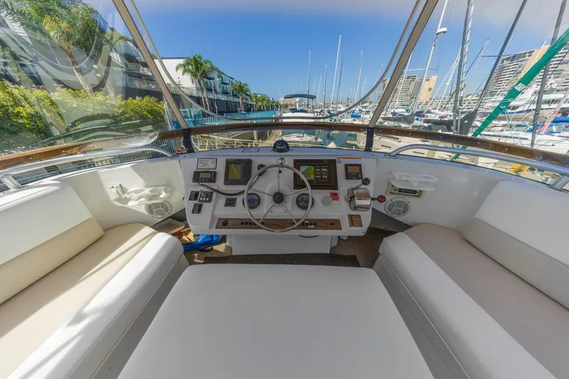 Slide: The Image of 2001 Mainship 390 Trawler helm with marina view, featuring navigation controls and seating. - 15
