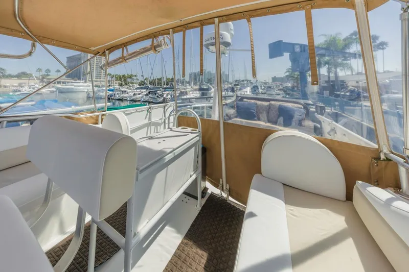 Slide: The Image of 2001 Mainship 390 Trawler interior with marina view, featuring seating and helm area. - 19