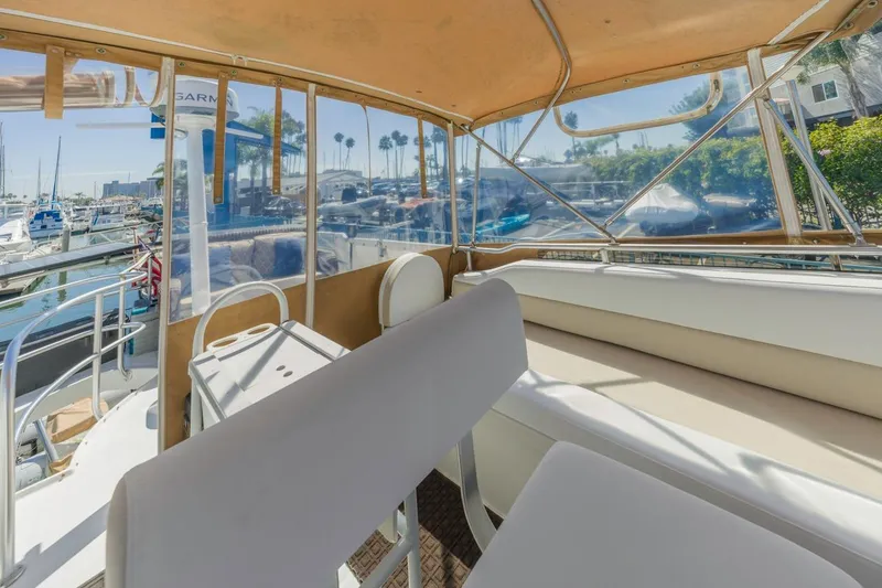 Slide: The Image of 2001 Mainship 390 Trawler interior with seating, marina view, and clear canopy. - 20