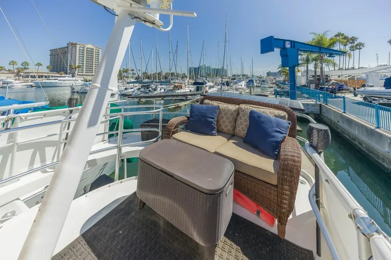 Slide: The Image of 2001 Mainship 390 Trawler with outdoor seating, docked at a marina with sailboats. - 21