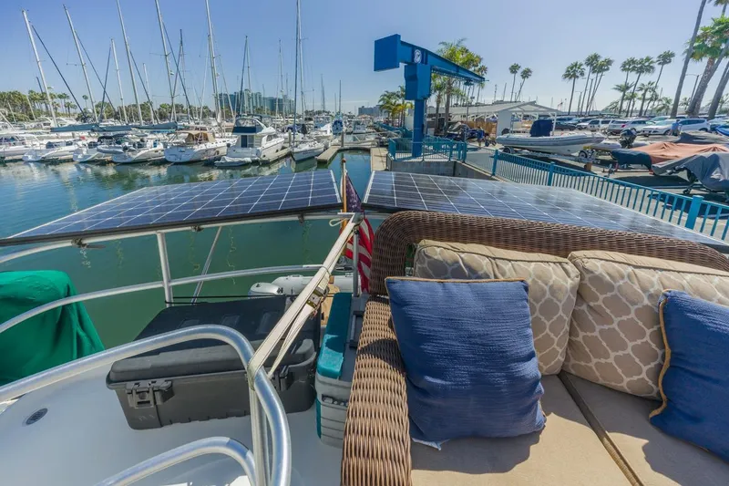 Slide: The Image of 2001 Mainship 390 Trawler with solar panels docked at a marina, featuring comfortable seating. - 22