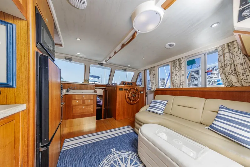 Slide: The Image of Interior of 2001 Mainship 390 Trawler with cozy seating and nautical decor. - 24