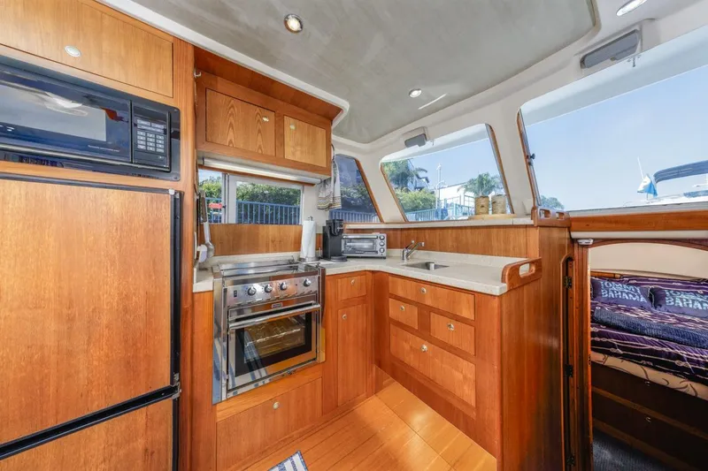 Slide: The Image of Interior of 2001 Mainship 390 Trawler kitchen with wood cabinetry and modern appliances. - 25