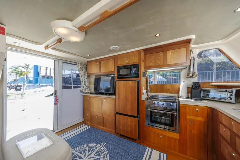Slide: The Image of Interior of 2001 Mainship 390 Trawler with wooden cabinetry and modern kitchen appliances. - 28