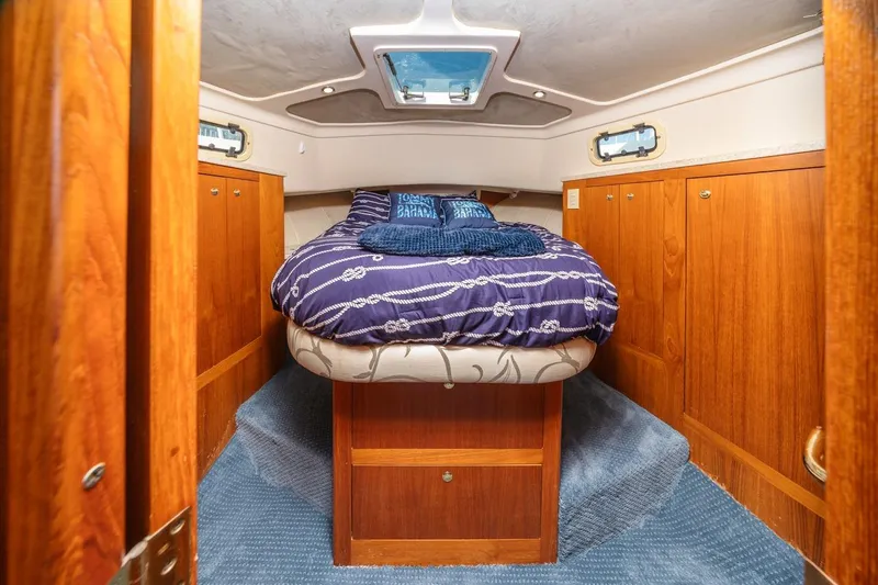Slide: The Image of 2001 Mainship 390 Trawler cabin with cozy bed, wooden cabinets, and nautical decor. - 33