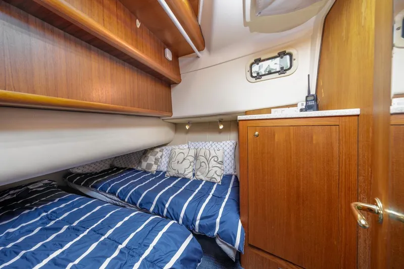 Slide: The Image of 2001 Mainship 390 Trawler cabin with twin beds, wooden cabinetry, and nautical decor. - 35