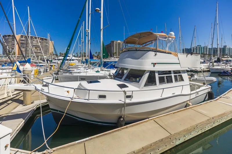 Slide: The Image of 2001 Mainship 390 Trawler docked in a marina with sailboats and buildings. - 7