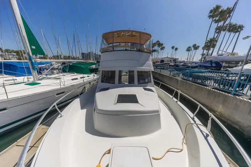 Slide: The Image of 2001 Mainship 390 Trawler docked at marina with sailboats and palm trees. - 8