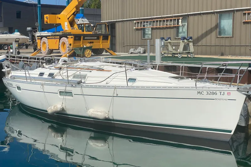 Slide: The Image of 1999 Beneteau Oceanis 352 sailboat docked at marina, reflecting on calm water. - 0