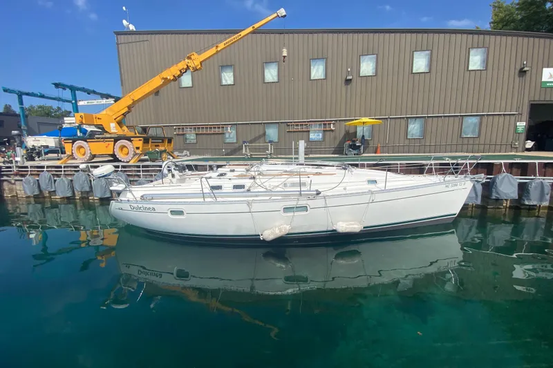 Slide: The Image of 1999 Beneteau Oceanis 352 sailboat docked at marina, reflecting on calm water. - 1