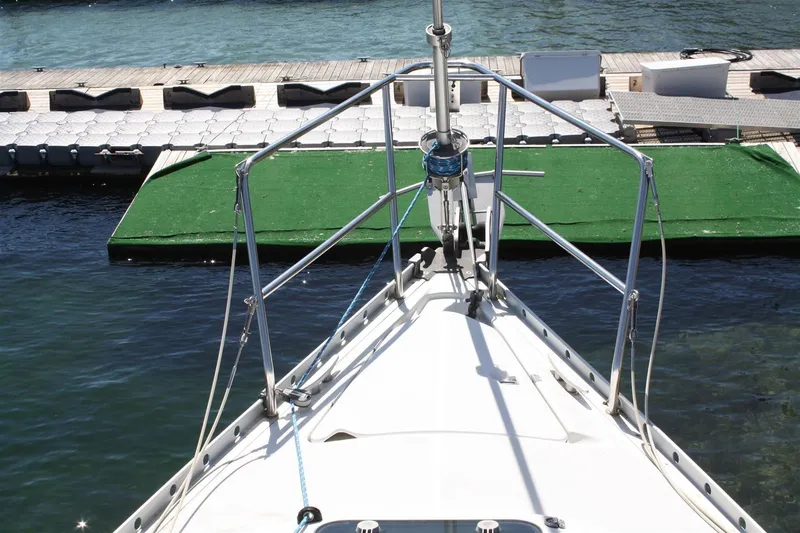 Slide: The Image of Bow view of a 1999 Beneteau Oceanis 352 sailboat docked at a marina. - 12