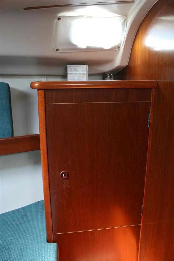 Slide: The Image of 1999 Beneteau Oceanis 352 interior with wooden cabinet and teal seating. - 17