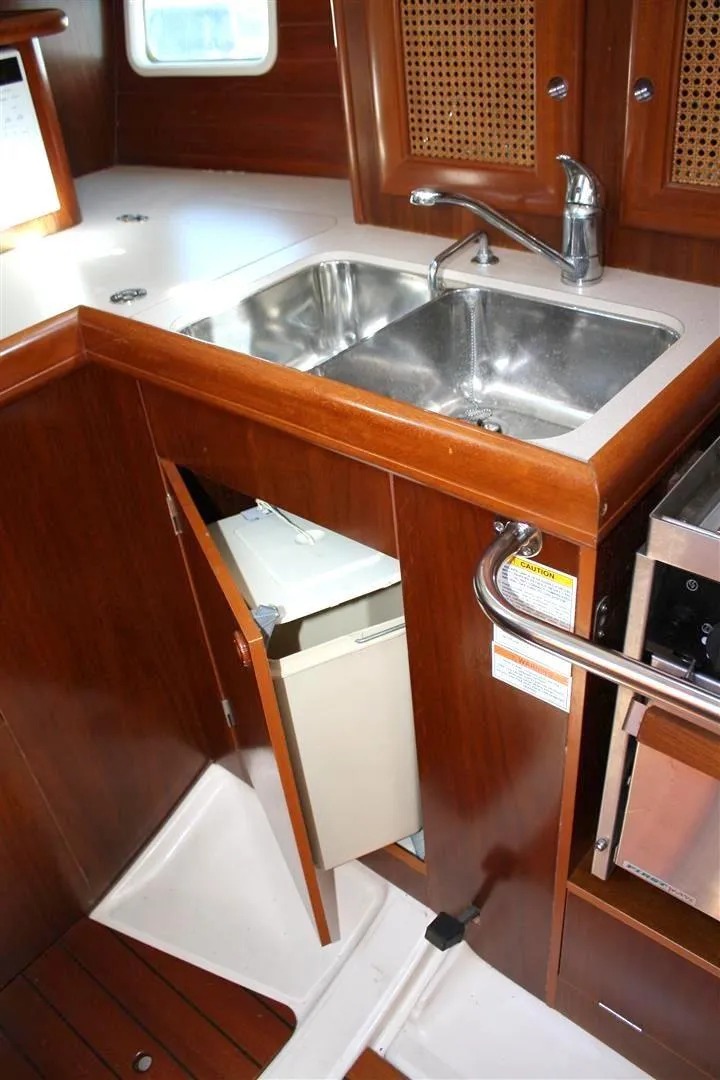 Slide: The Image of 1999 Beneteau Oceanis 352 yacht kitchen with dual sinks and wooden cabinetry. - 23