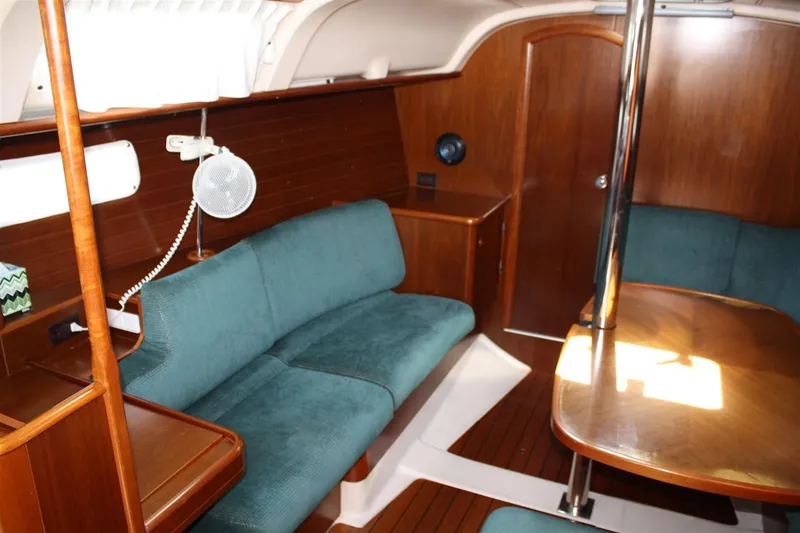 Slide: The Image of Interior of 1999 Beneteau Oceanis 352 sailboat with teal seating and wooden finishes. - 26