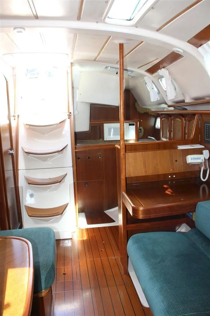 Slide: The Image of Interior of 1999 Beneteau Oceanis 352 sailboat with wooden finishes and seating area. - 29