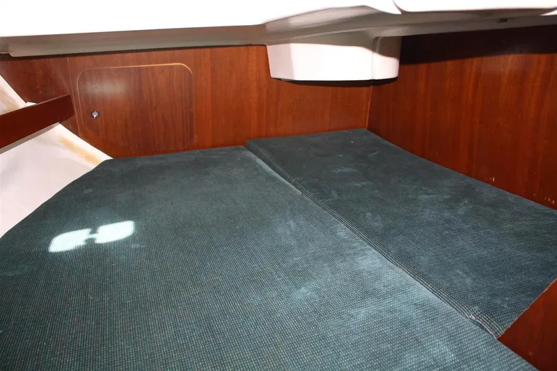 Slide: The Image of 1999 Beneteau Oceanis 352 cabin interior with green cushions and wooden paneling. - 33