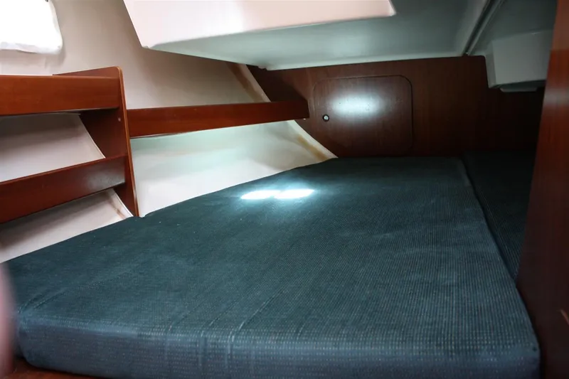 Slide: The Image of 1999 Beneteau Oceanis 352 cabin interior with wooden finish and blue mattress. - 34