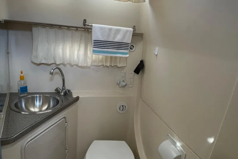 Slide: The Image of 2011 Regal 3060 Express Cruiser interior with dining area, TV, and wooden steps. - 24