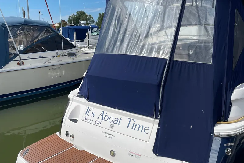 Slide: The Image of 2011 Regal 3060 Express Cruiser docked, featuring blue canopy and wooden deck. - 35