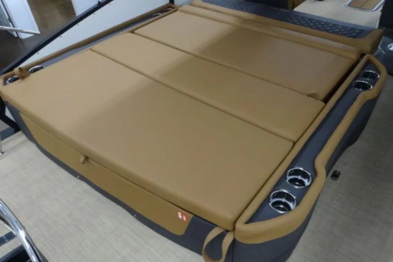 Slide: The Image of 2026 Harris Sunliner 250 boat interior with tan cushioned seating and cup holders. - 7