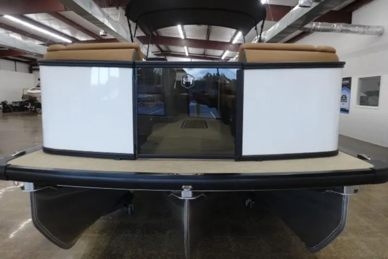 Slide: The Image of 2026 Harris Sunliner 250 pontoon boat in showroom, rear view with seating and canopy. - 9