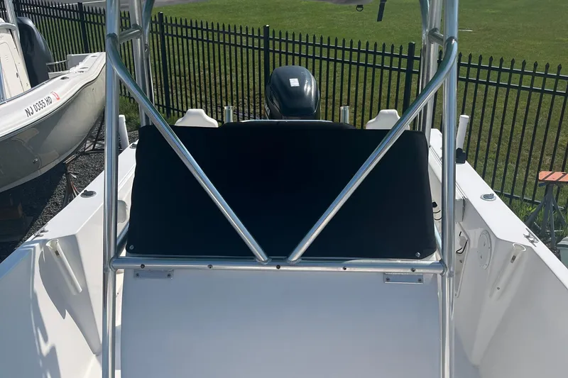 Slide: The Image of 2006 Seaquest 2200 BW boat with metal frame and outboard motor, docked near a fence. - 7
