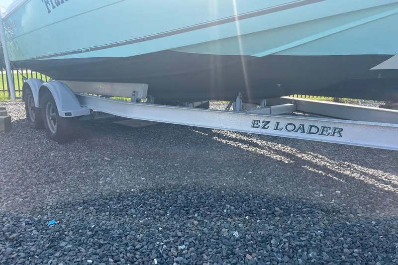 Slide: The Image of 2006 Seaquest 2200 BW boat on EZ Loader trailer, parked on gravel. - 8