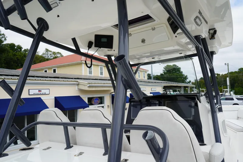 Slide: The Image of 2020 Sea Fox 328 Commander boat interior with helm and seating, docked near a building. - 27