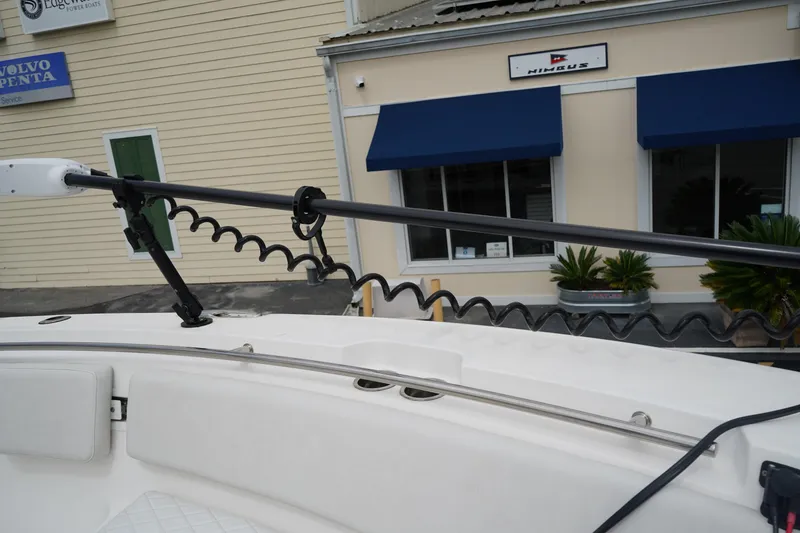 Slide: The Image of 2020 Sea Fox 328 Commander boat with trolling motor, docked near a building with blue awnings. - 68
