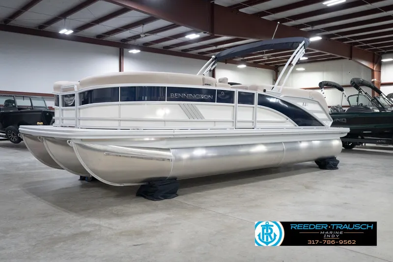 Slide: The Image of 2026 Bennington 22 ML pontoon boat displayed indoors at Reeder-Trausch Marine showroom. - 64