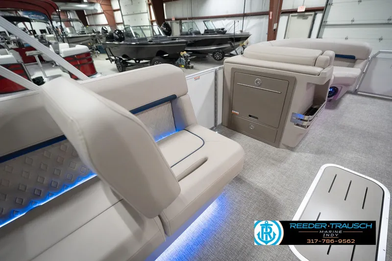 Slide: The Image of 2026 Bennington 22 ML boat interior with beige seating and blue LED lighting. - 89