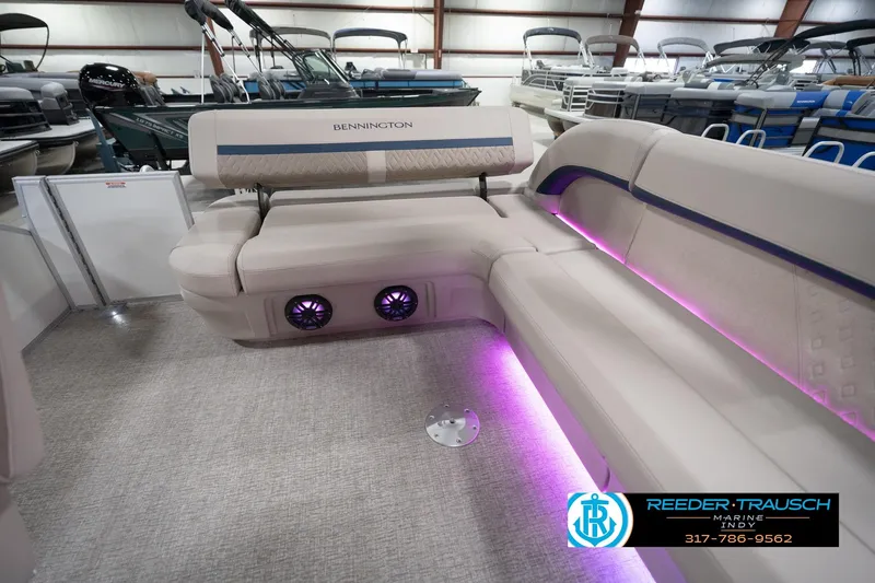 Slide: The Image of 2026 Bennington 22 ML pontoon boat interior with plush seating and ambient purple lighting. - 94