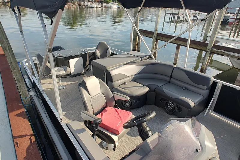 Slide: The Image of 2023 Tahoe Pontoon LTZ Rear Fish 22' with seating and canopy on a calm lake. - 4