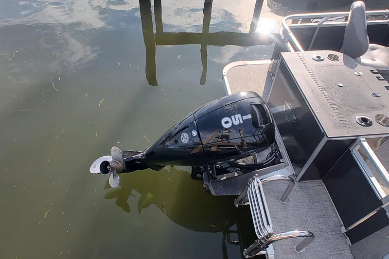 Slide: The Image of 2023 Tahoe Pontoon LTZ Rear Fish boat with outboard motor, docked on calm water. - 5