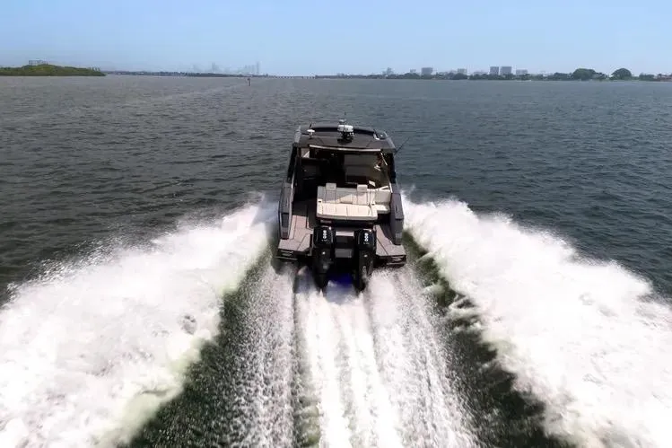 Slide: The Image of 2023 Cruisers 42 GLS OB speeding on open water, showcasing powerful outboard engines. - 1