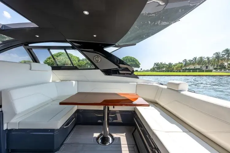 Slide: The Image of Luxurious 2023 Cruisers 42 GLS OB yacht interior with elegant seating and table, overlooking serene waters. - 12