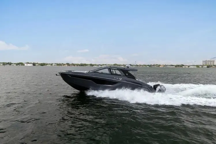 Slide: The Image of 2023 Cruisers 42 GLS OB boat cruising on open water under clear blue sky. - 2