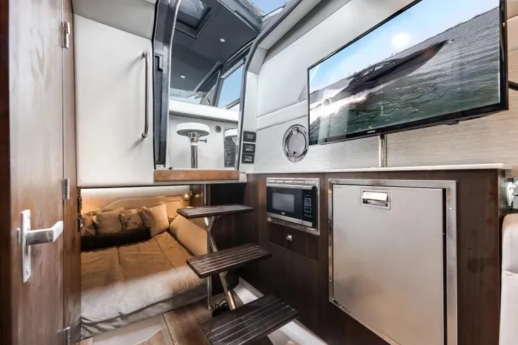 Slide: The Image of 2023 Cruisers 42 GLS OB interior with bed, TV, microwave, and stairs. - 41