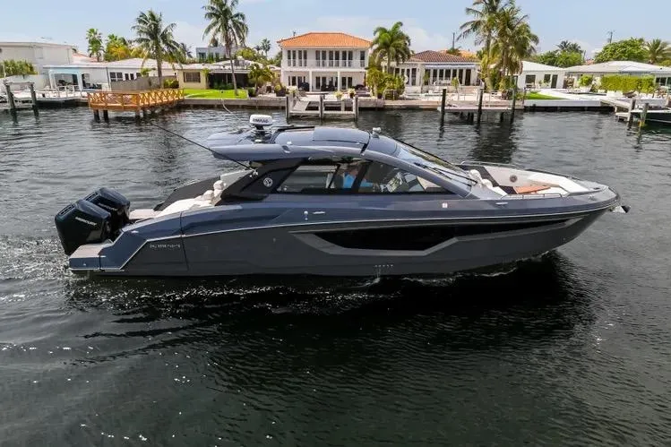 Slide: The Image of 2023 Cruisers 42 GLS OB yacht cruising near waterfront homes, showcasing sleek design and luxury. - 46